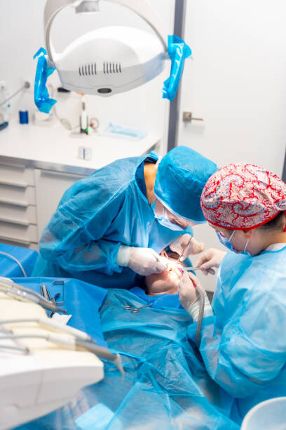 Moment of an oral operation by two dentists on the work table